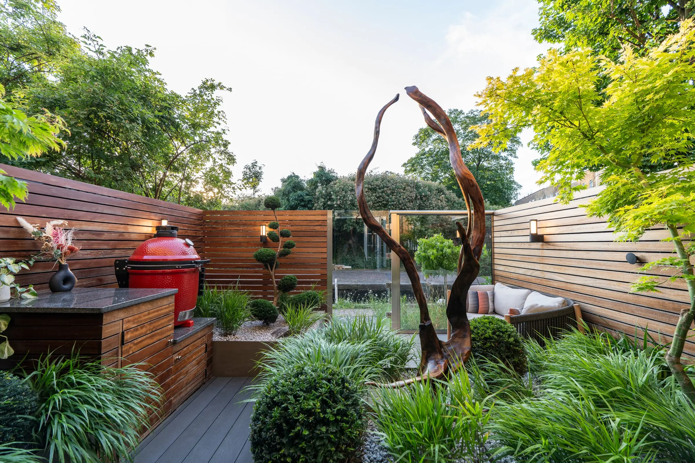 Sculptural driftwood centrepiece among lush planting in Victoria Park