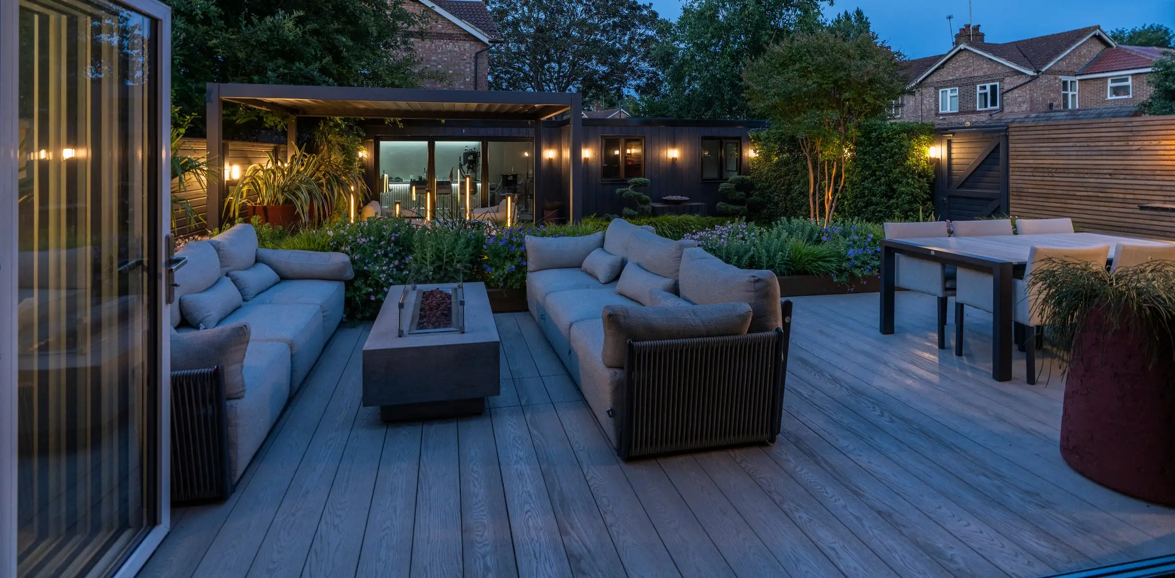 Evening lounge with a fire table on a decked terrace in Richmond