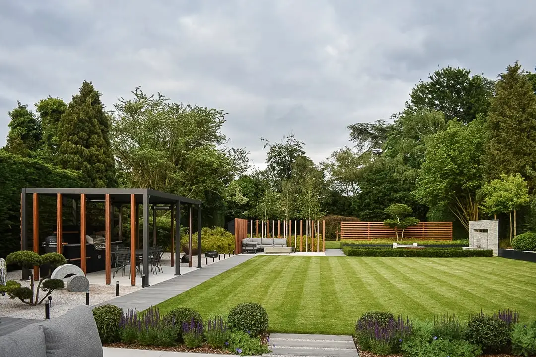 Striped lawn framed by a timber pergola and clipped topiary in Sutton